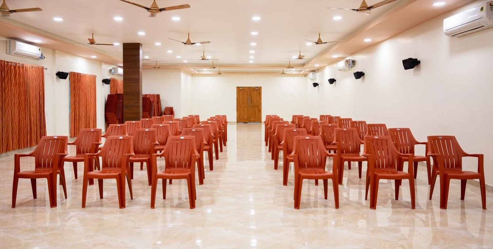 Conference hall seating from the rear, showing the aisle and speaker system